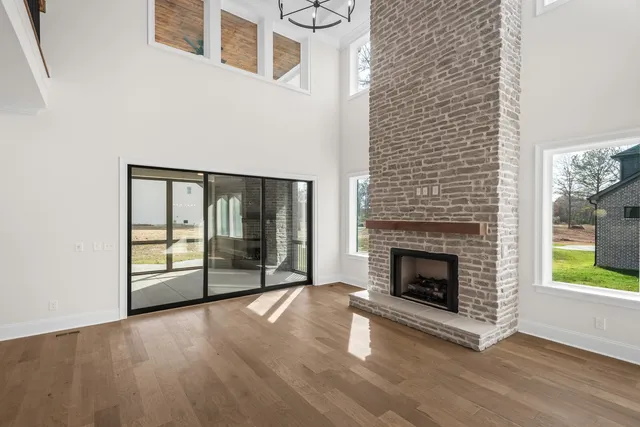 a living room with a fireplace and large windows