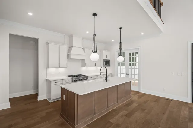 a large kitchen with granite countertop a stove a sink a refrigerator and a dining table