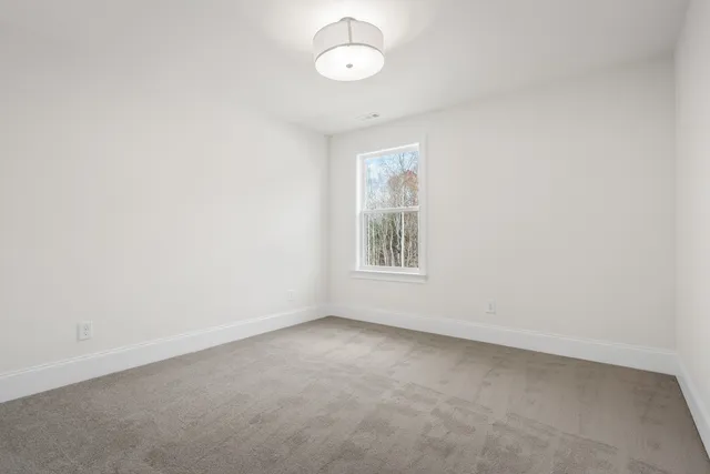a view of an empty room with a fireplace and a window