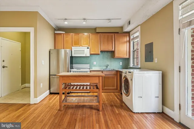 a kitchen with stainless steel appliances granite countertop a refrigerator a stove and a wooden floors