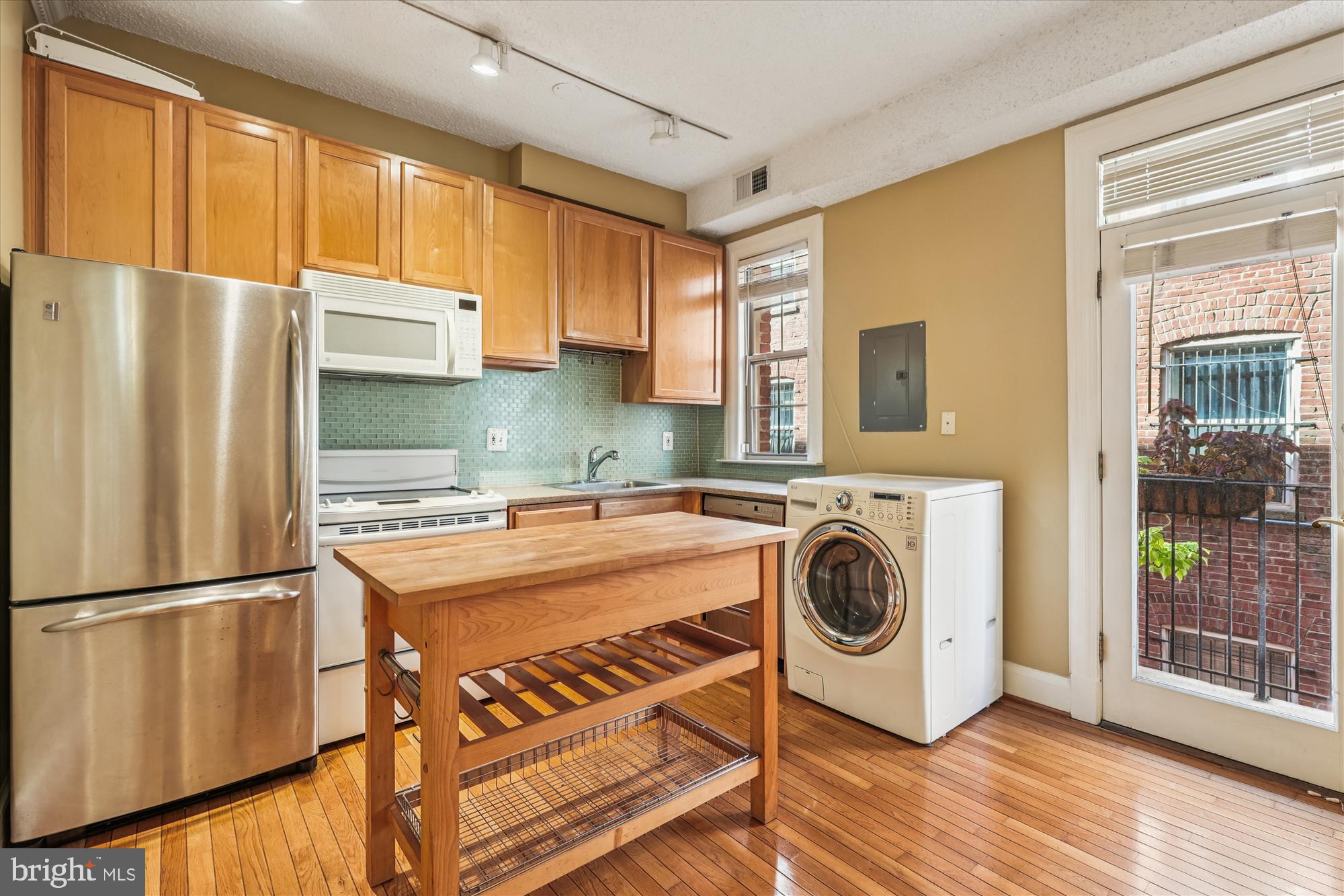 1401 Columbia Road Northwest, Unit 209 Washington, DC 20009 - Photo 7 of 34 a view of a kitchen with fridge and wooden floor
