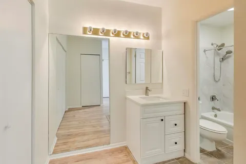 a spacious bathroom with a shower a sink and a mirror