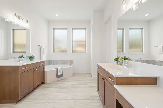 a bathroom with a tub a sink and a mirror