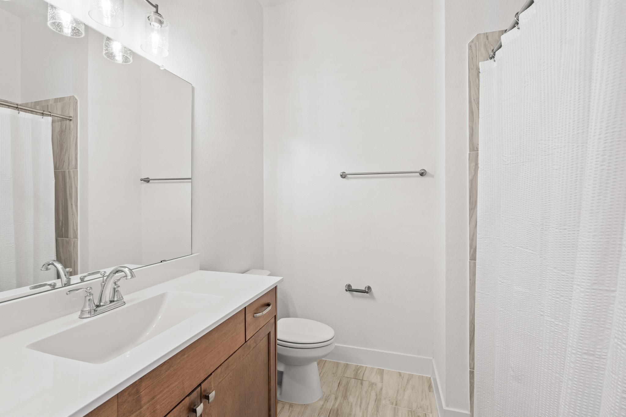 7403 Hanover Lane Katy, TX 77493 - Photo 27 of 46 This private secondary bathroom is connected to the first secondary bedroom and features a combination tub/shower and a spacious vanity with quartz countertops, large mirror, and warm cabinets.