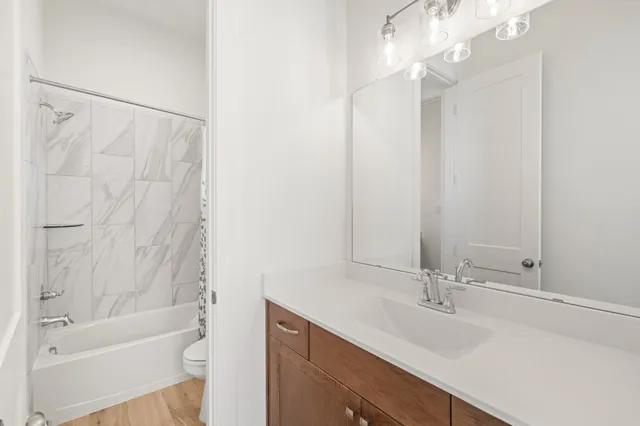 a bathroom with a sink a toilet and shower