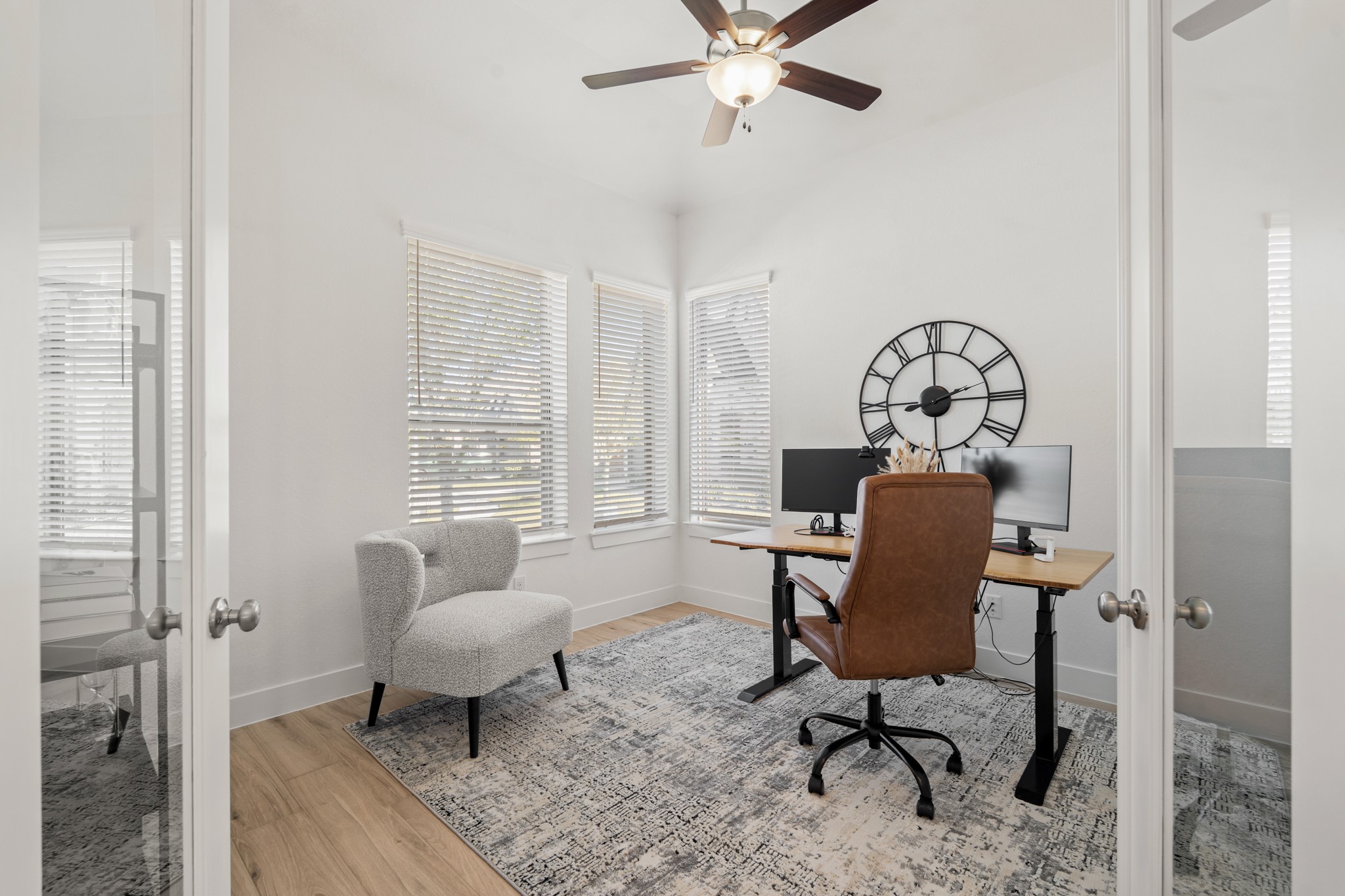 7403 Hanover Lane Katy, TX 77493 - Photo 6 of 46 Nestled away quietly in the front of the home is the home office! Featuring high ceilings, wood like flooring, French doors, a ceiling fan and large windows, this is the ideal space to work from home!