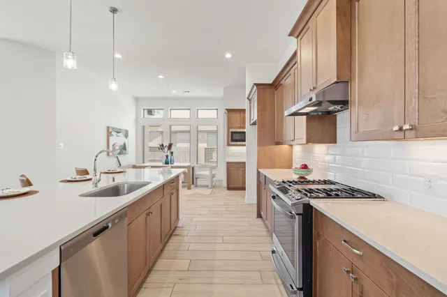 a kitchen with kitchen island granite countertop a sink and a stove