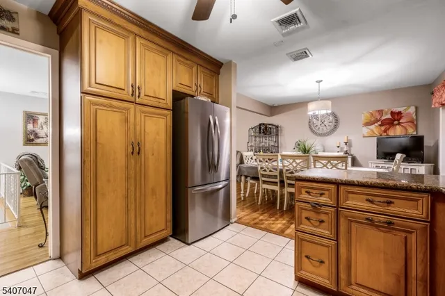 a kitchen with stainless steel appliances granite countertop a refrigerator and a stove top oven