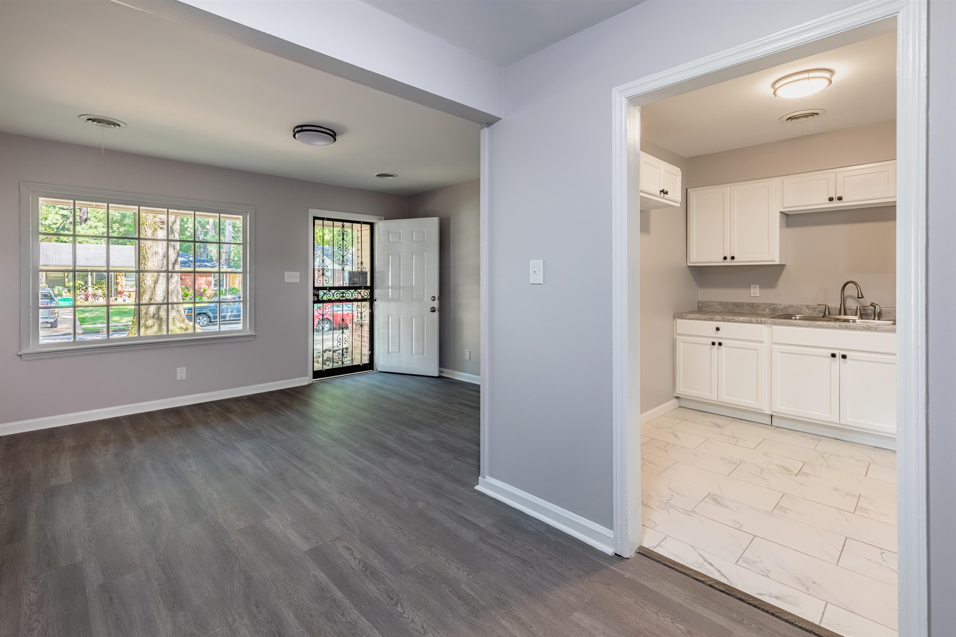 4400 Helene Road Memphis, TN 38117 - Photo 11 of 31 a view of a kitchen and an empty room with wooden floor and a window