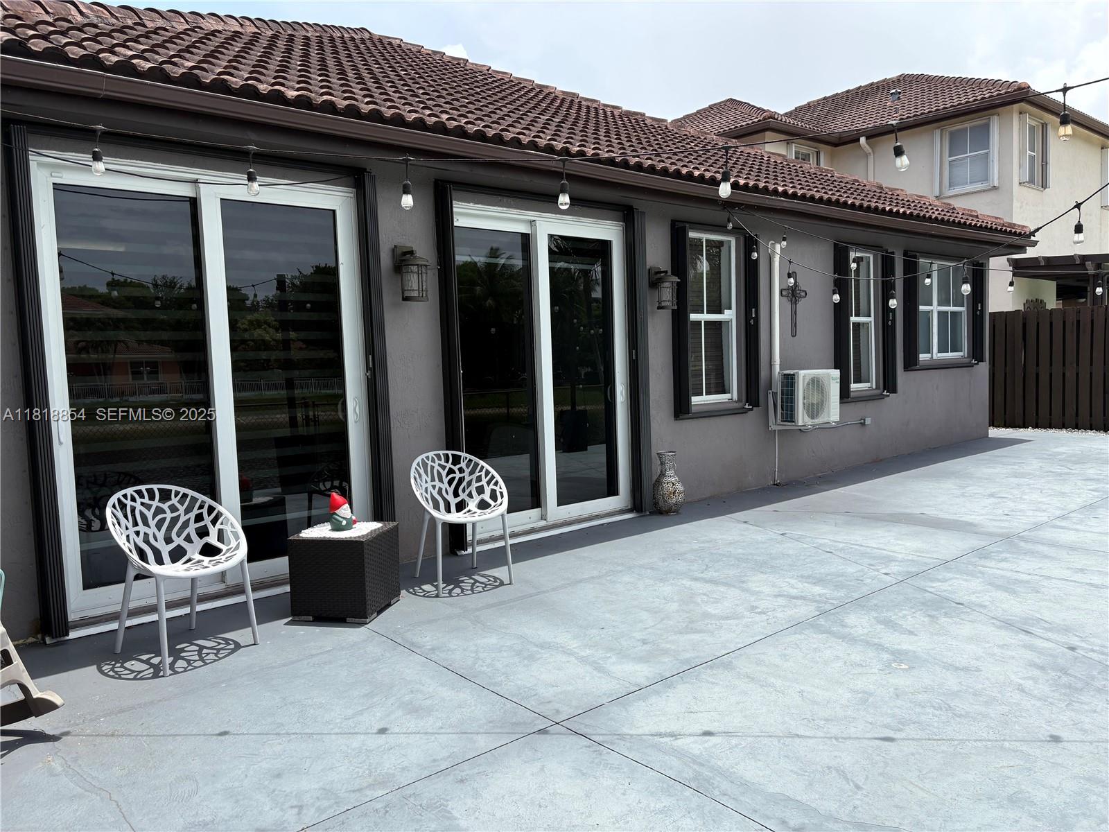 16419 Southwest 84th Street Miami, FL 33193 - Photo 13 of 15 a view of a patio with a table and chairs and floor to ceiling window