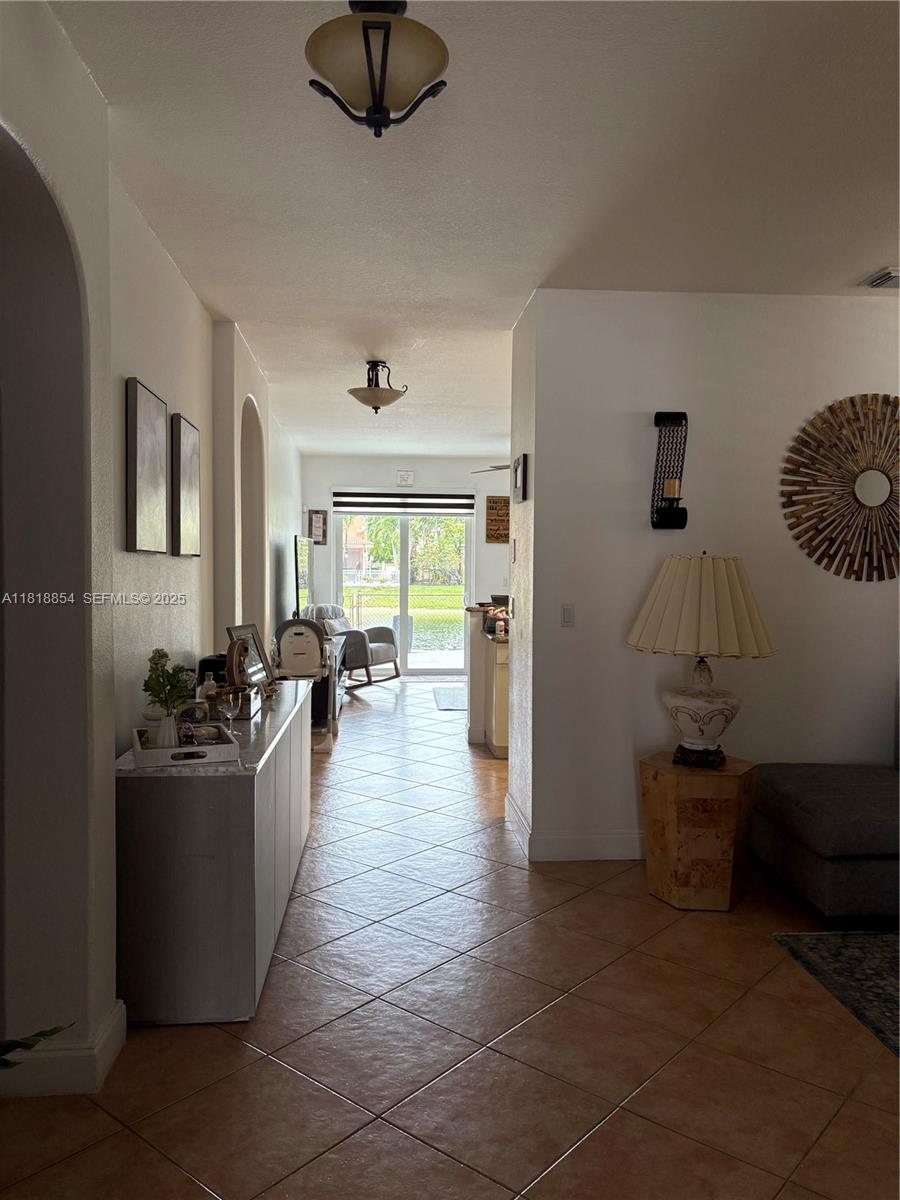 16419 Southwest 84th Street Miami, FL 33193 - Photo 2 of 15 a living room with couches and kitchen view with wooden floor