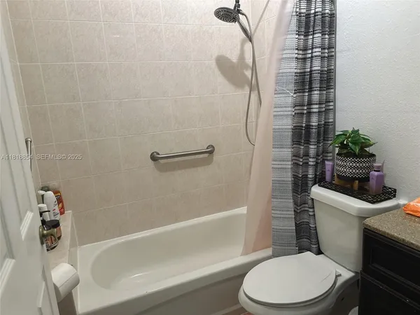a white toilet sitting next to a bath tub