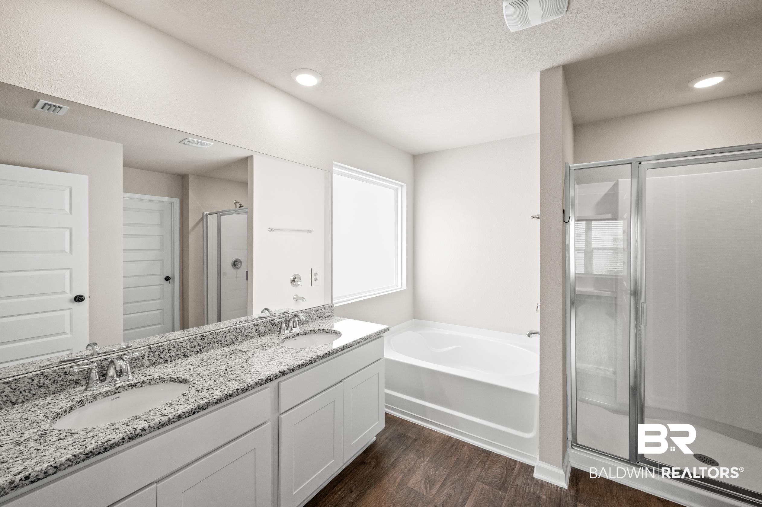 10353 Zenyatta Loop Daphne, AL 36526 - Photo 16 of 33 Bathroom featuring double vanity, plus walk in shower, wood-type flooring, and a wealth of natural light