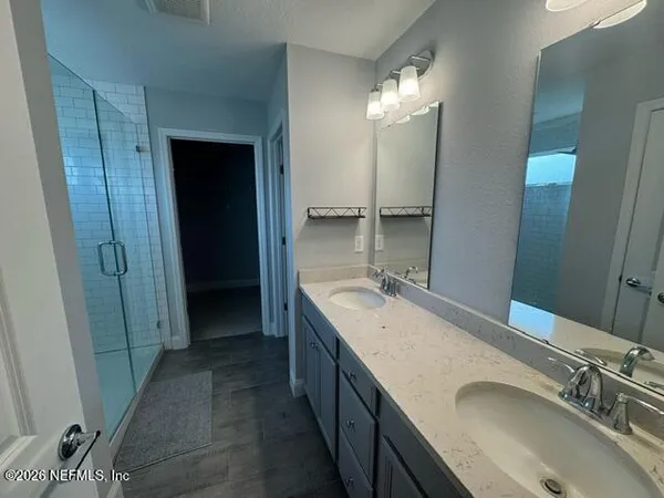 a bathroom with a double vanity sink and mirror