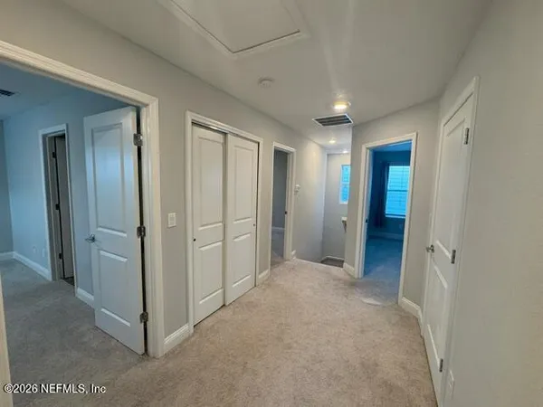 a view of a hallway with wooden shelves
