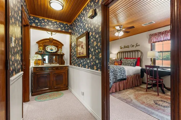 a bedroom with a bed and a dresser next to a window