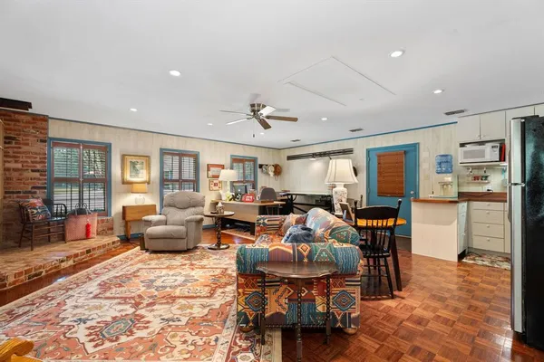 a living room with furniture kitchen view and a large window