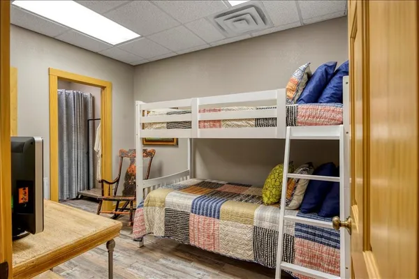 a bedroom with a bed and a flat tv screen on the table
