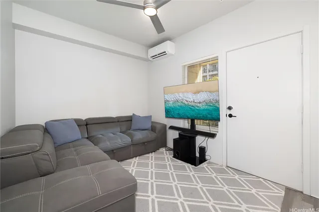 a living room with furniture a flat screen tv and a window