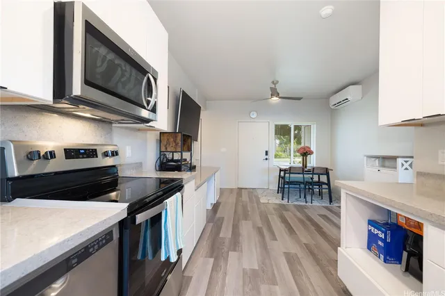 a kitchen with stainless steel appliances granite countertop a stove top oven a sink a dining table and chairs with wooden floor