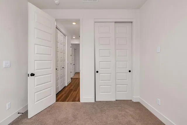 an empty room with closet and a bathroom