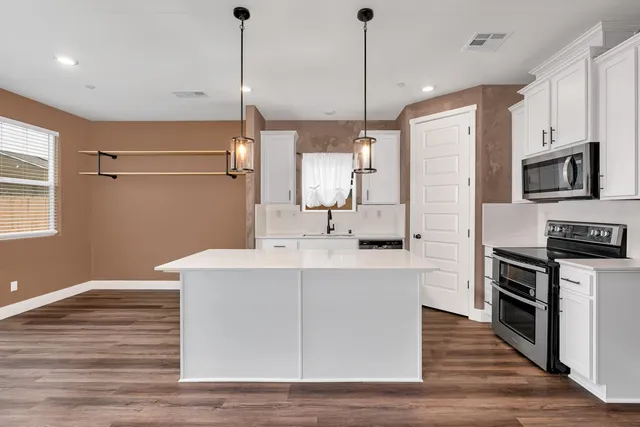 a kitchen with stainless steel appliances kitchen island granite countertop a refrigerator a sink and dishwasher