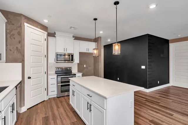 a kitchen with stainless steel appliances a refrigerator and a stove top oven