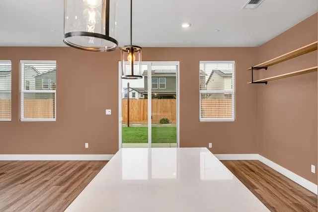 a white house with a big yard and large trees