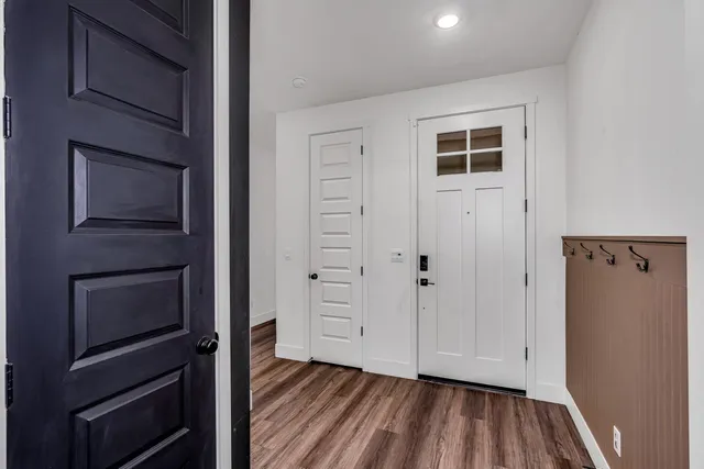 a view of an empty room with closet and wooden floor