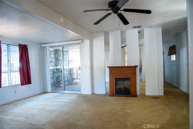 a view of empty room with fireplace and fan