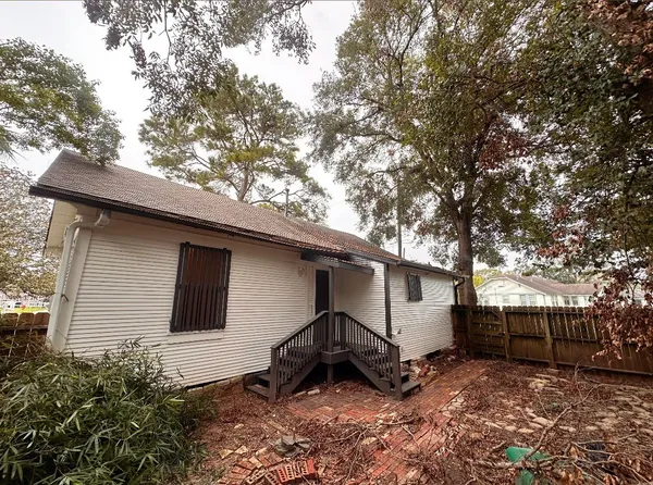 a backyard of a house with barbeque oven and trees