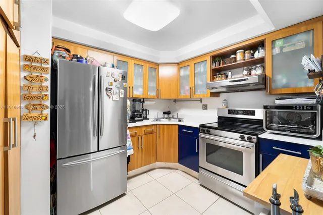 a kitchen with stainless steel appliances granite countertop a refrigerator sink and stove