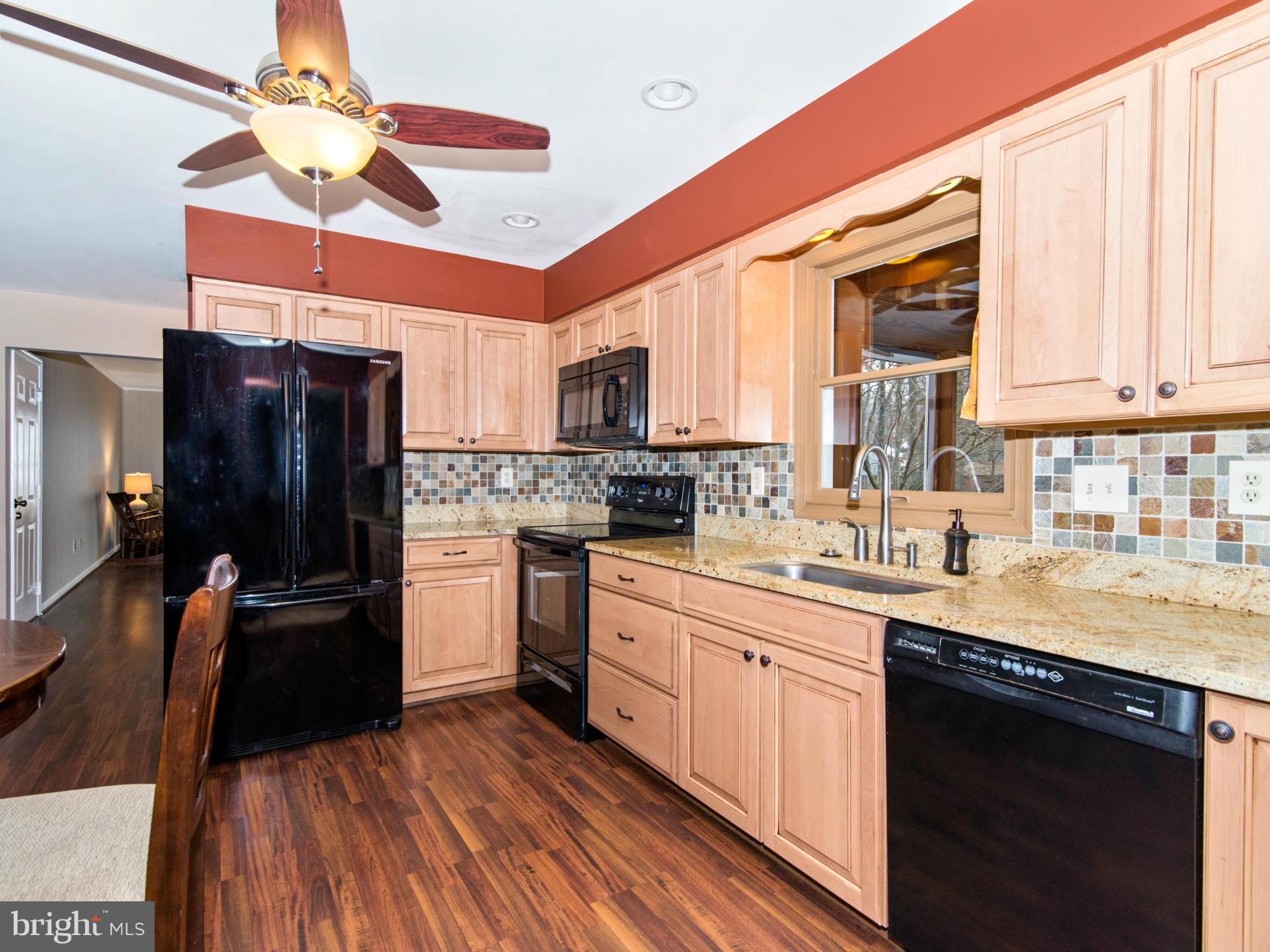 127 Summit Hall Road Gaithersburg, MD 20877 - Photo 13 of 30 a kitchen with stainless steel appliances granite countertop a refrigerator a sink dishwasher a stove and white countertops with wooden floor