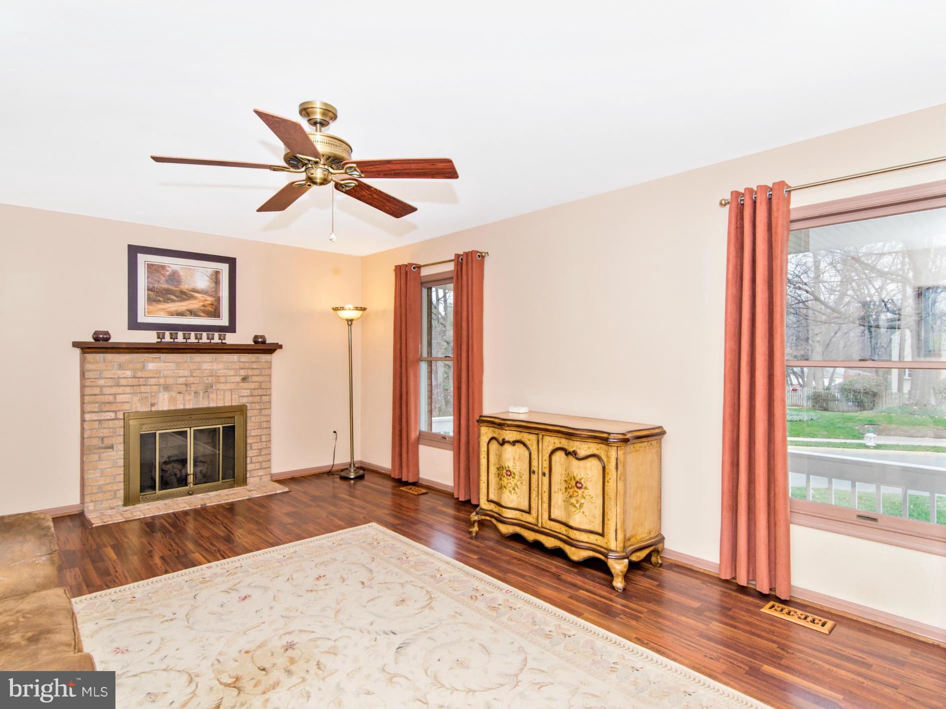 127 Summit Hall Road Gaithersburg, MD 20877 - Photo 6 of 30 a living room with a fireplace flat screen tv and a large window