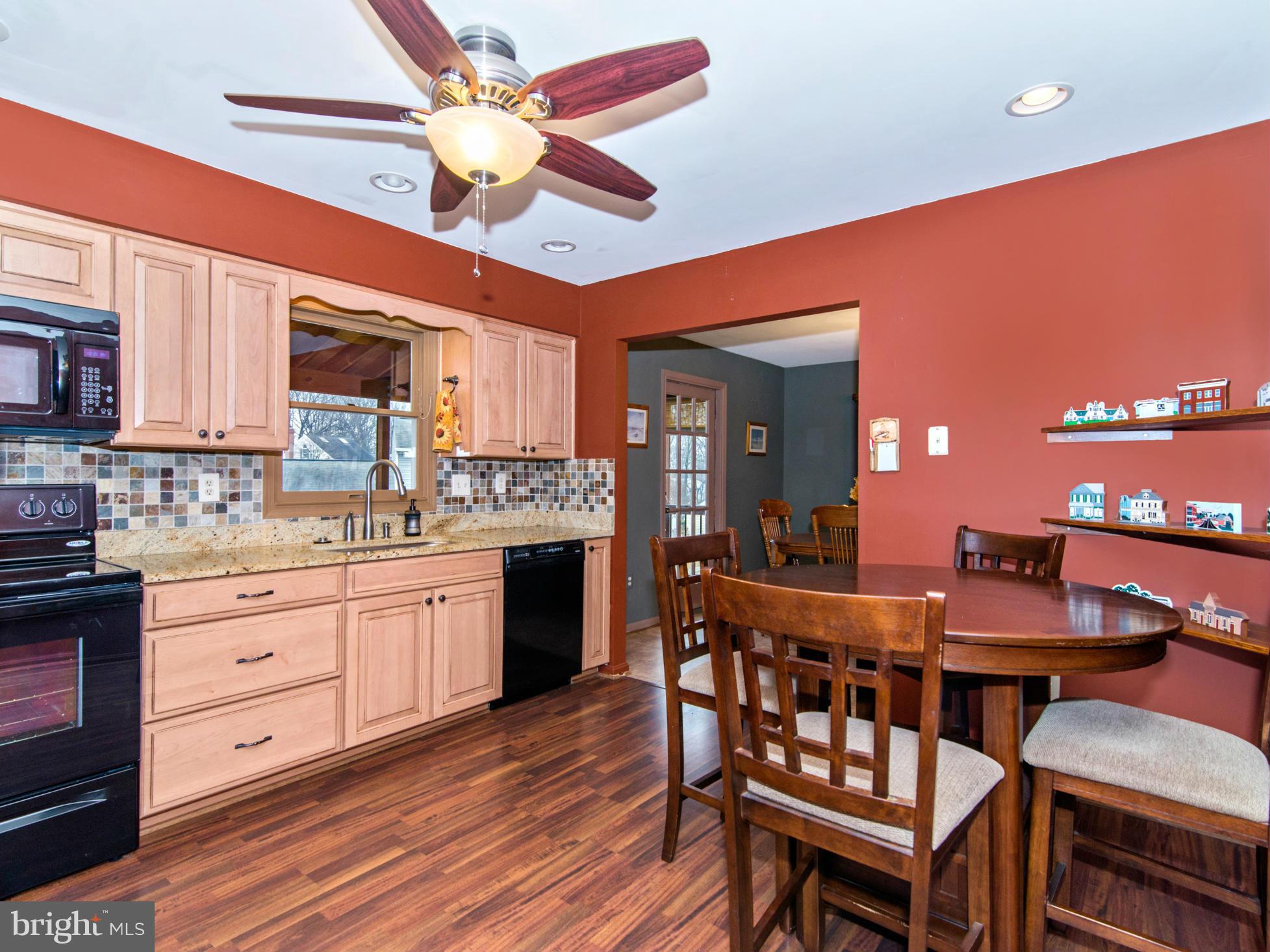 127 Summit Hall Road Gaithersburg, MD 20877 - Photo 10 of 30 a kitchen with stainless steel appliances granite countertop a kitchen island hardwood floor sink stove dining table and chairs