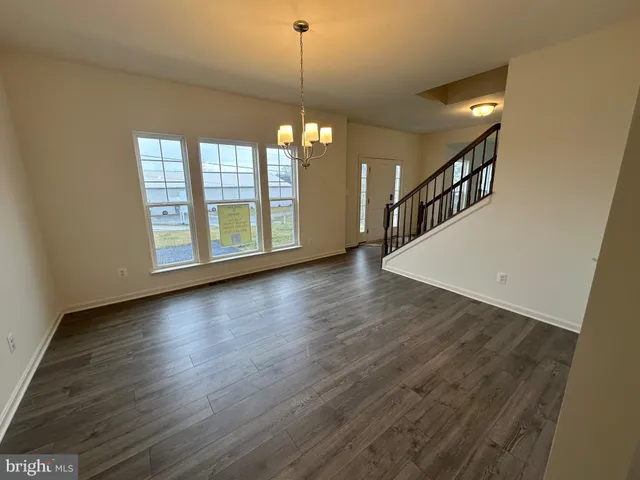 a view of a hallway with wooden floor and stairs