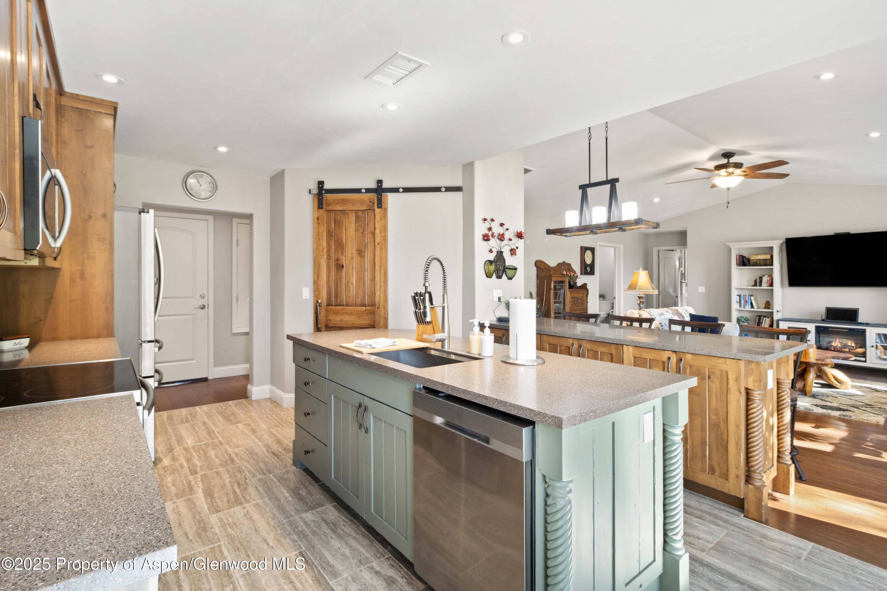 3211 County Road 237 Rifle, CO 81650 - Photo 25 of 56 a kitchen with stainless steel appliances kitchen island granite countertop a sink and cabinets