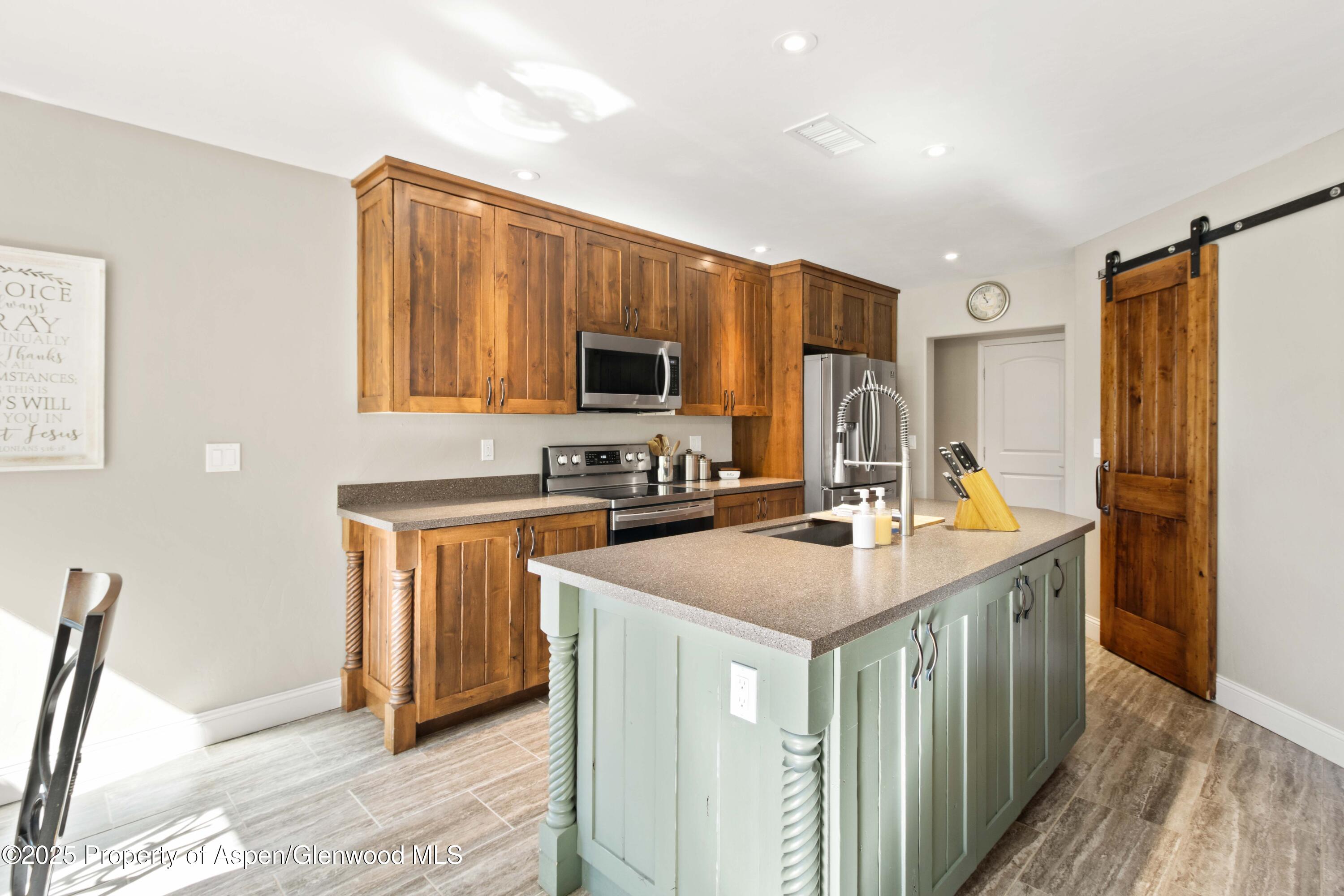3211 County Road 237 Rifle, CO 81650 - Photo 26 of 56 a kitchen with kitchen island granite countertop a sink stove and refrigerator