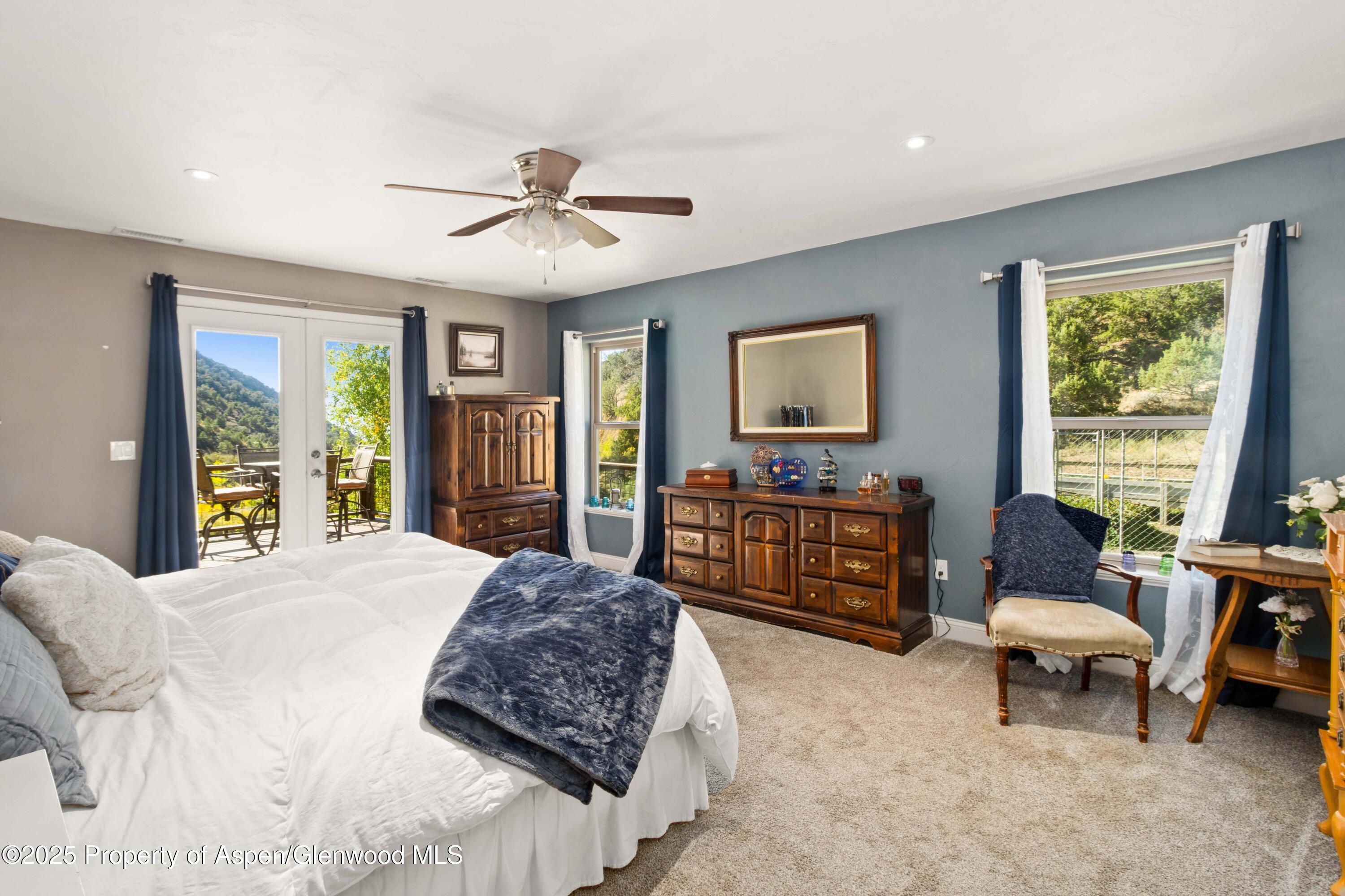 3211 County Road 237 Rifle, CO 81650 - Photo 32 of 56 a spacious bedroom with a bed a dresser and a chandelier