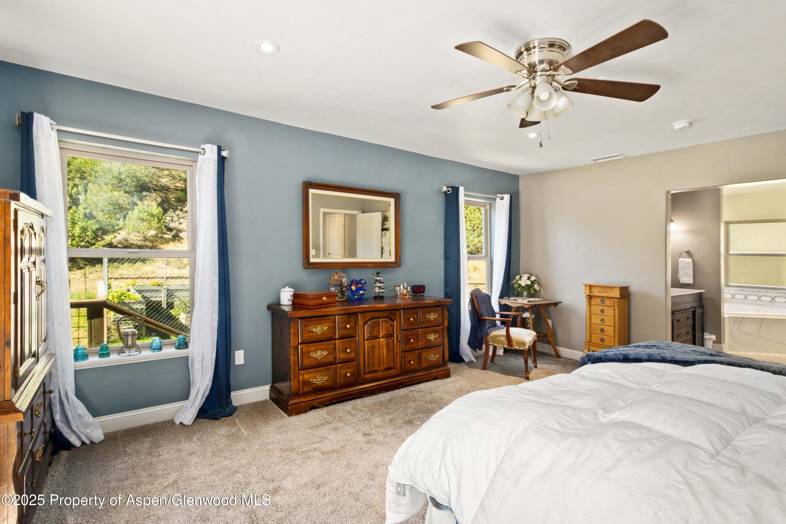 3211 County Road 237 Rifle, CO 81650 - Photo 33 of 56 a bedroom with a bed and a chandelier