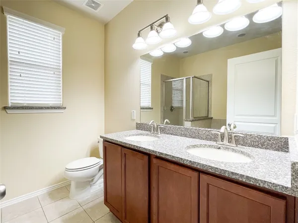 a bathroom with a granite countertop sink a toilet and a mirror