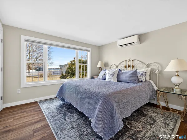 a bedroom with bed and wooden floor