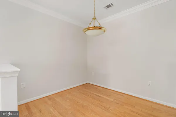 a view of empty room with wooden floor and ceiling fan