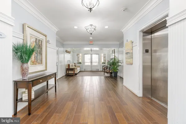 a view of a hallway with wooden floor and a livingroom