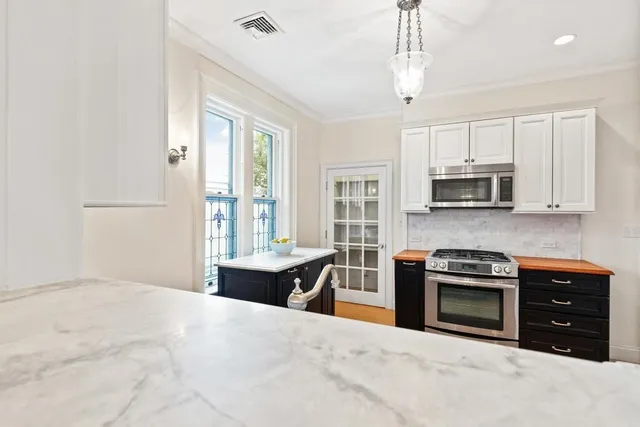 a kitchen with granite countertop a stove sink and microwave