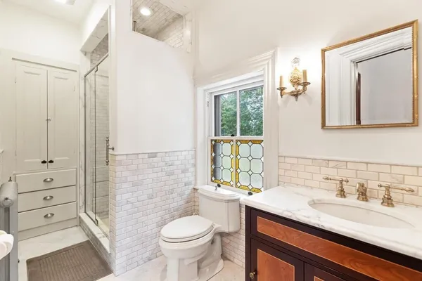 a bathroom with a granite countertop sink toilet and shower
