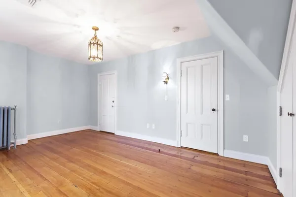 a view of empty room with wooden floor and window