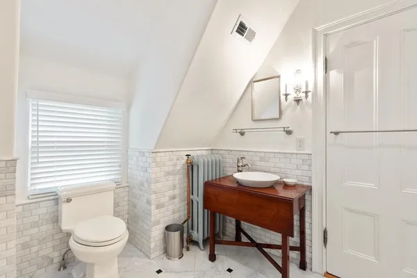 a bathroom with a toilet a sink and a mirror