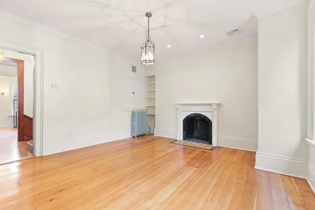 a view of empty room with wooden floor and fireplace