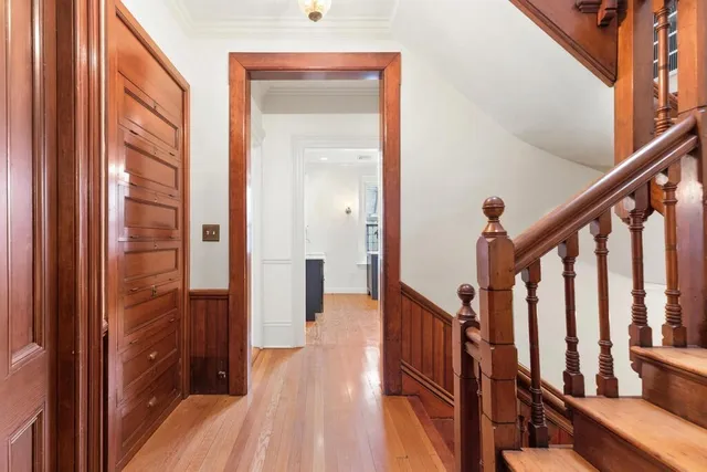 a view of a hallway with wooden floor and staircase